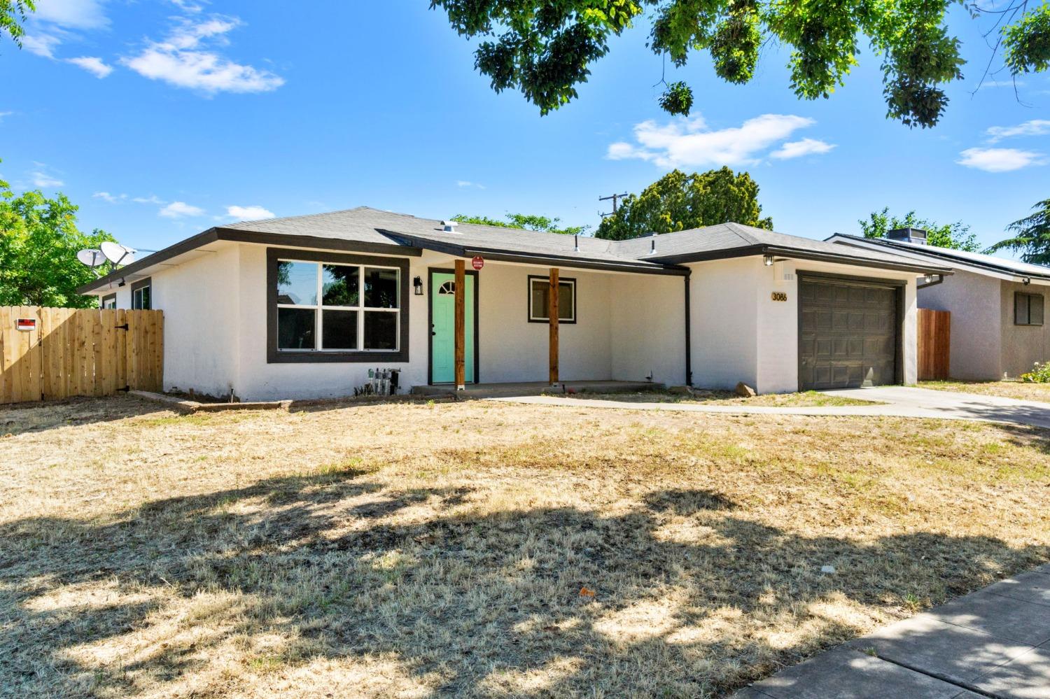 3086 West Hampton Way Fresno, CA 93722 - Photo 3 of 33 a front view of a house with a garage