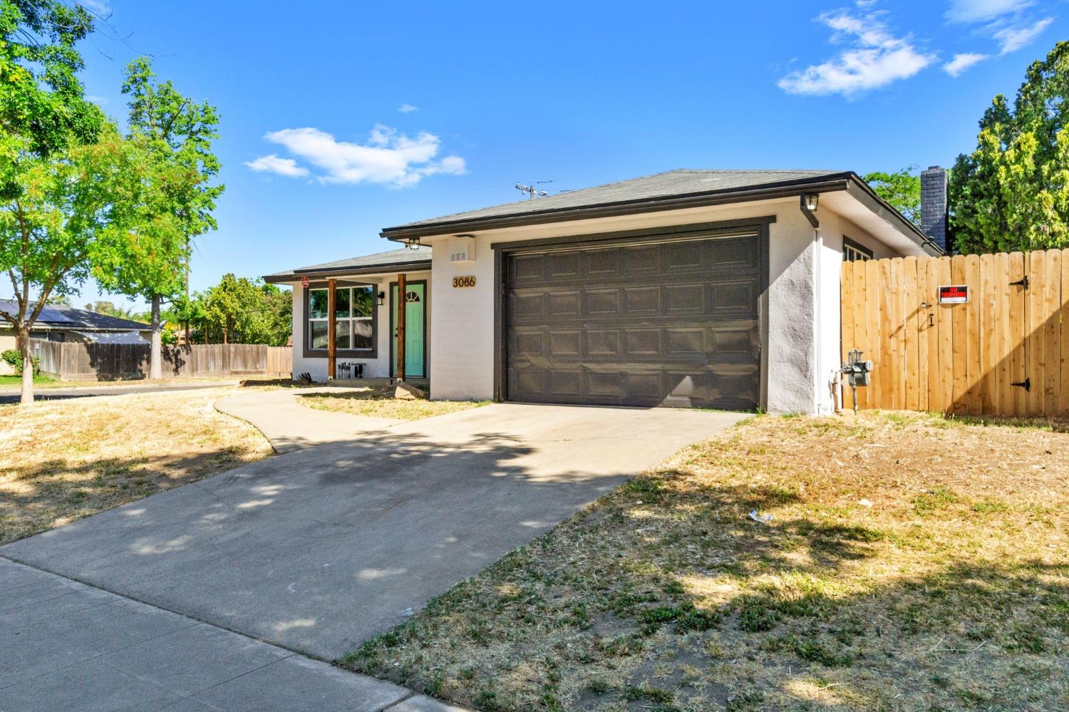 3086 West Hampton Way Fresno, CA 93722 - Photo 4 of 33 a front view of a house with a yard