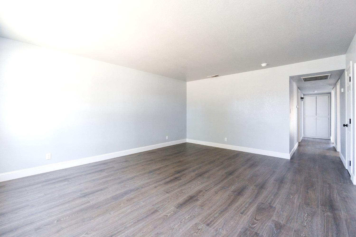 3086 West Hampton Way Fresno, CA 93722 - Photo 6 of 33 a view of an empty room with wooden floor