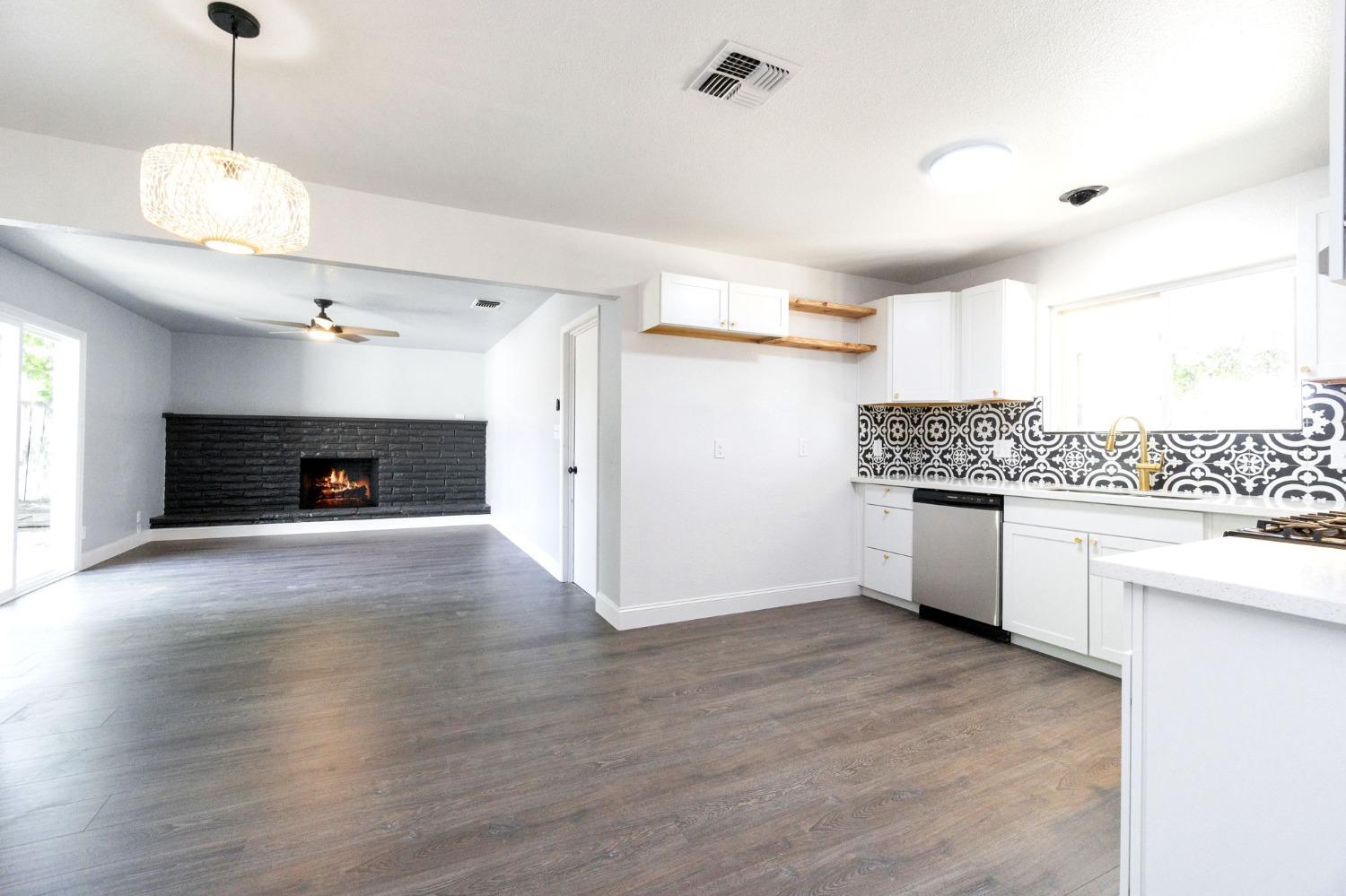 3086 West Hampton Way Fresno, CA 93722 - Photo 10 of 33 a large kitchen with kitchen island a sink stainless steel appliances and cabinets
