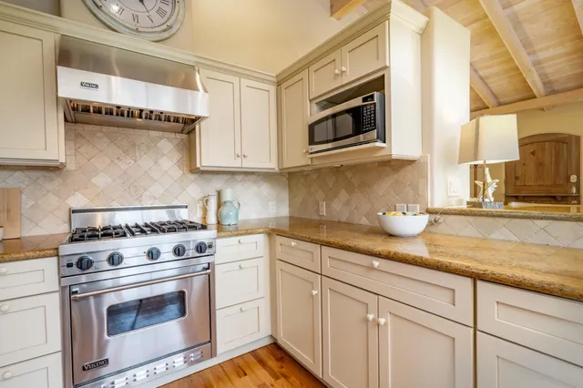 a kitchen with stainless steel appliances granite countertop a sink a stove and a microwave