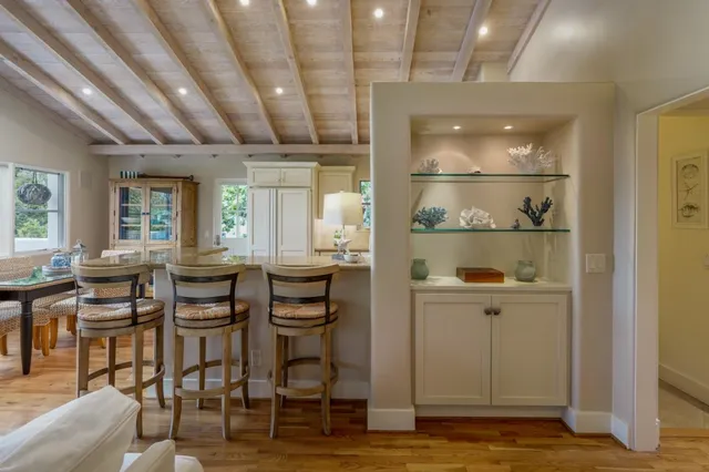 a room with lots of wooden furniture and windows