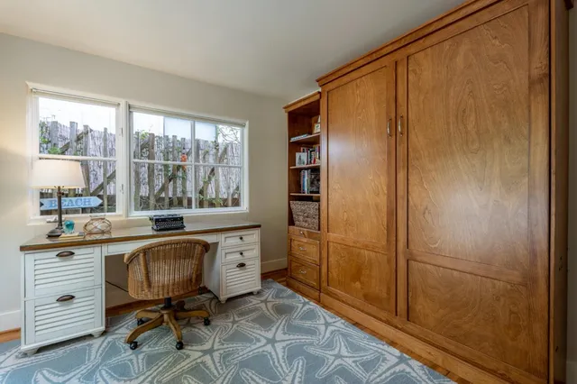 a view of a workspace with furniture and a window
