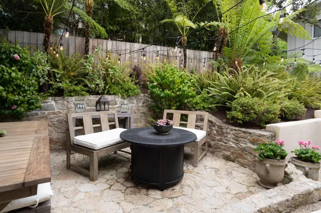 a table and chairs in a backyard of the house