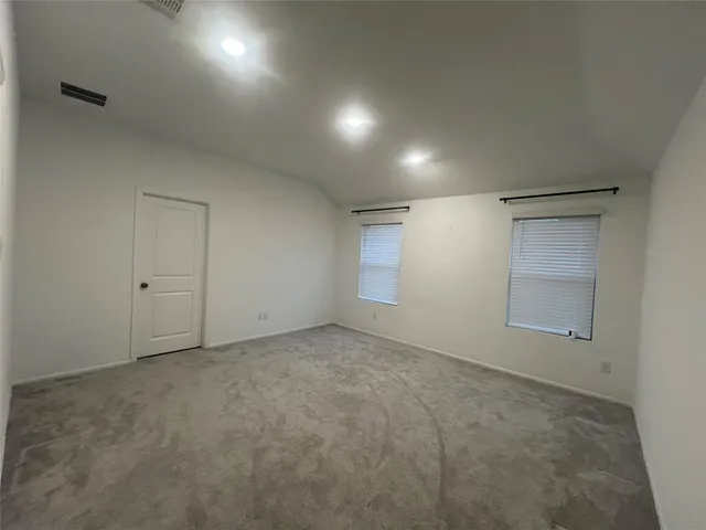 an empty room with closet and windows