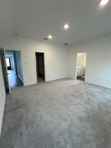 an empty room with windows and entrance to other room
