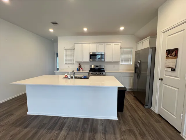 a kitchen with stainless steel appliances a refrigerator and a stove top oven