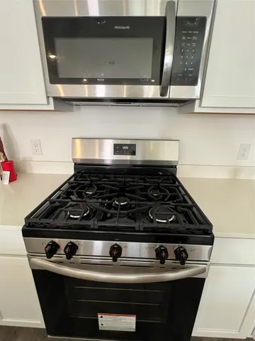 a stove top oven sitting inside of a kitchen