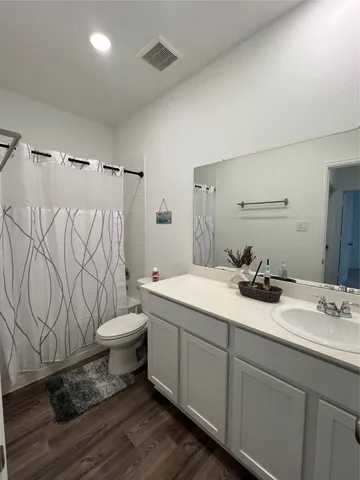 a bathroom with a granite countertop toilet sink and mirror