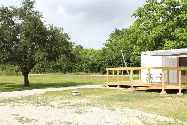 a view of a swimming pool with a lawn chairs and next to a yard
