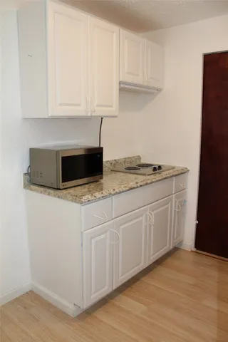 a kitchen with granite countertop white cabinets and white appliances