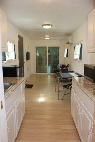 a kitchen with granite countertop a stove a sink and a wooden floors
