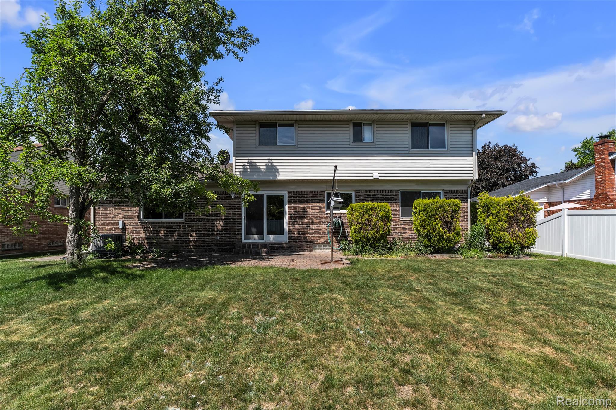 7000 Woonsocket Street Canton, MI 48187 - Photo 60 of 65 Brick and siding exterior with multiple windows and a large tree providing natural shade