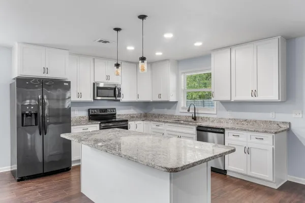a kitchen with a center island appliances and cabinets