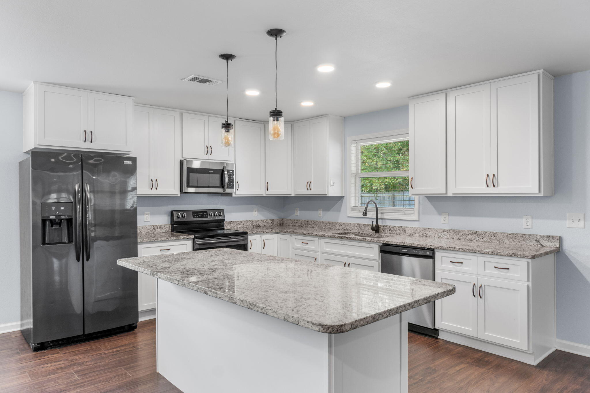 a kitchen with a center island appliances and cabinets