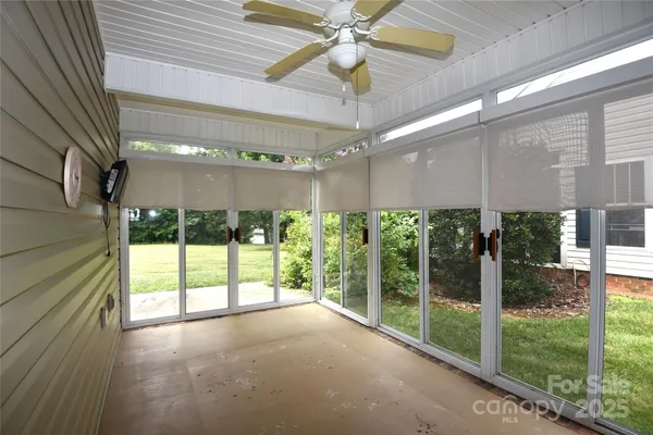 a view of a room with windows and ceiling fan