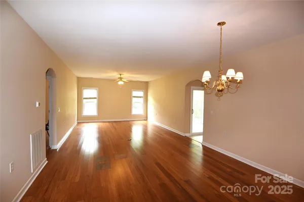 a view of a room with wooden floor and chandelier