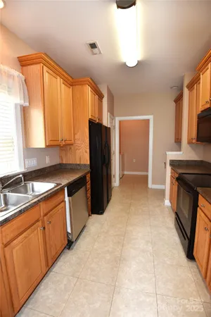 a large kitchen with a stove a sink dishwasher and a refrigerator