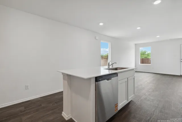 a kitchen with granite countertop a sink and wooden floor