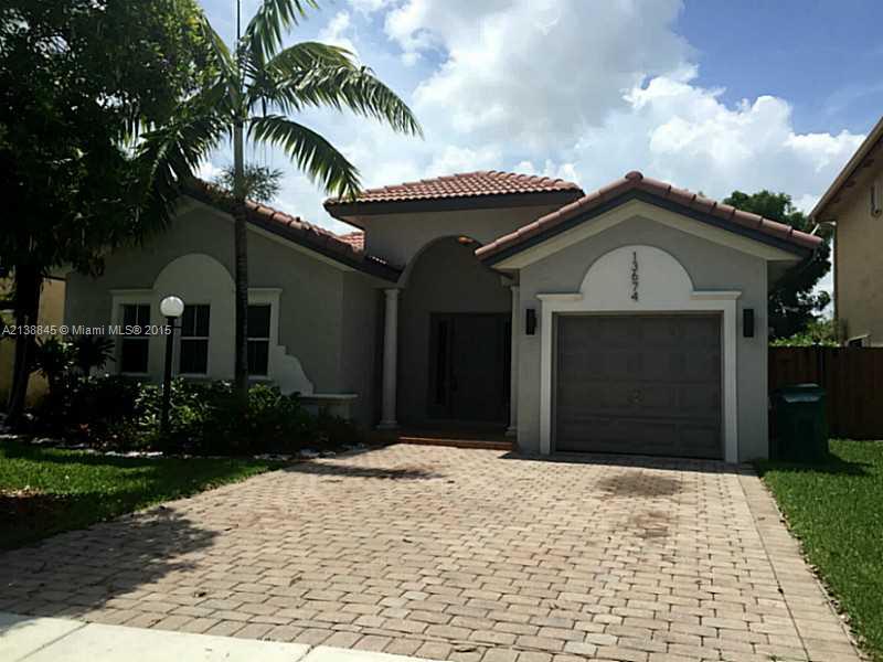 13674 Southwest 124th Avenue Road Miami, FL 33186 - Photo 1 of 21 a front view of a house with a yard