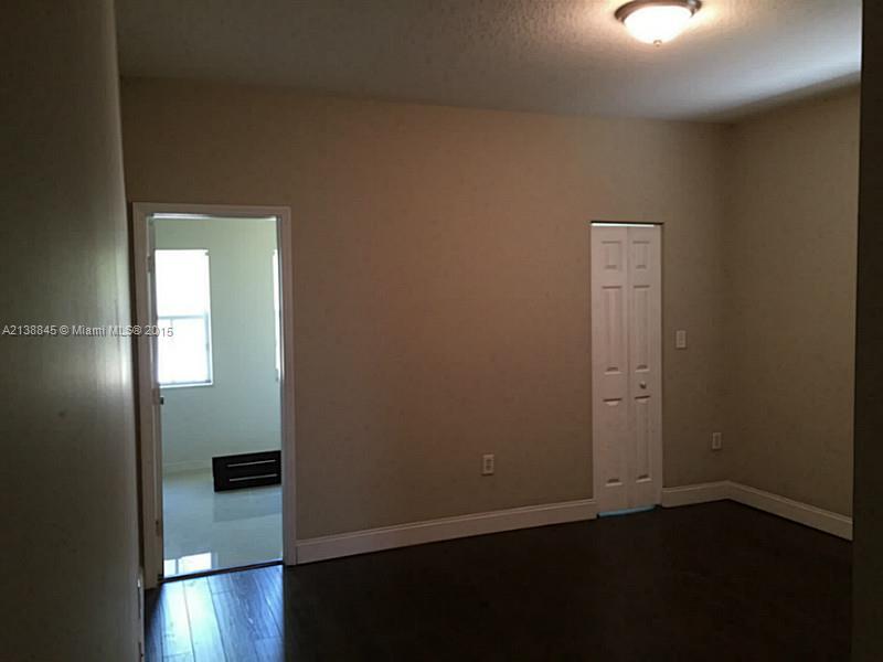13674 Southwest 124th Avenue Road Miami, FL 33186 - Photo 14 of 21 an empty room with wooden floor cabinet and windows