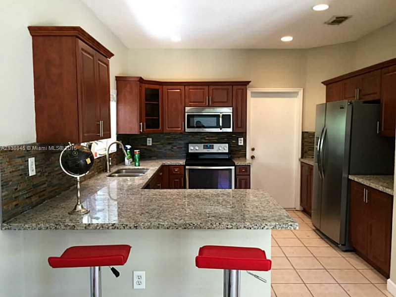 13674 Southwest 124th Avenue Road Miami, FL 33186 - Photo 7 of 21 a kitchen with stainless steel appliances kitchen island granite countertop a refrigerator and a sink