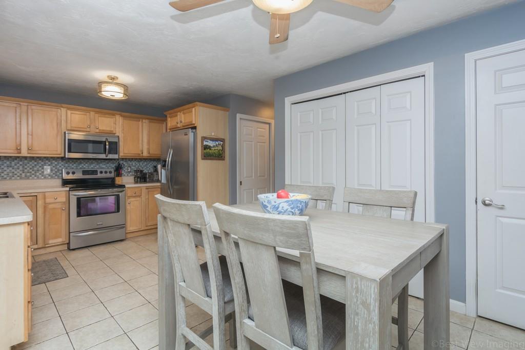 41 Tannery Road Sturbridge, MA 01518 - Photo 11 of 42 a kitchen with stainless steel appliances granite countertop a stove refrigerator a microwave oven with a dining table and chairs