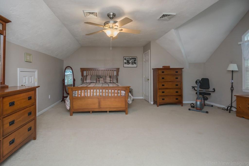 41 Tannery Road Sturbridge, MA 01518 - Photo 28 of 42 a spacious bedroom with a bed a dresser and a chandelier