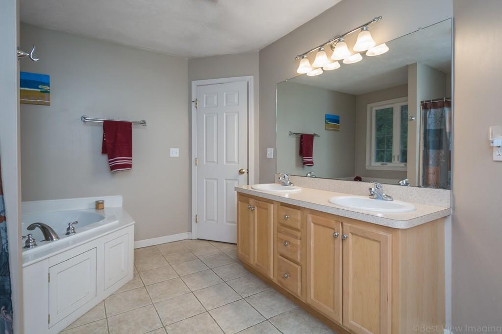 41 Tannery Road Sturbridge, MA 01518 - Photo 32 of 42 a spacious bathroom with a double vanity sink a mirror and a bathtub