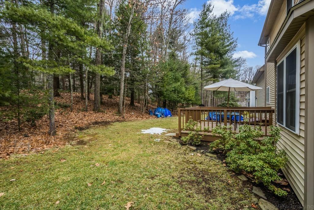 41 Tannery Road Sturbridge, MA 01518 - Photo 41 of 42 a balcony view with a table and chairs under an umbrella