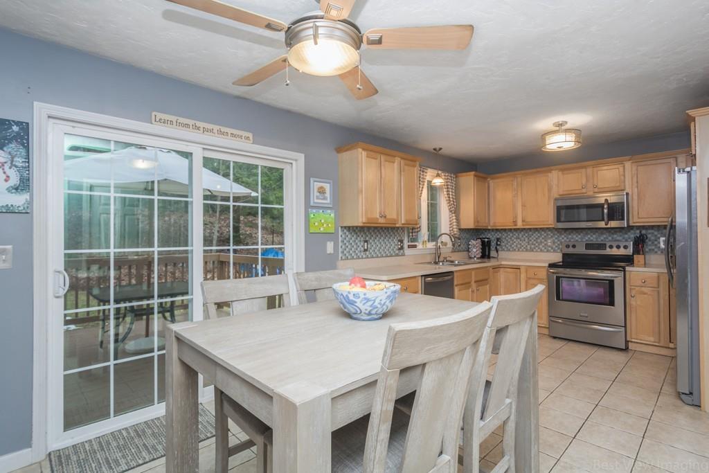 41 Tannery Road Sturbridge, MA 01518 - Photo 10 of 42 a kitchen with stainless steel appliances granite countertop a stove a refrigerator a sink a dining table and chairs with wooden floor