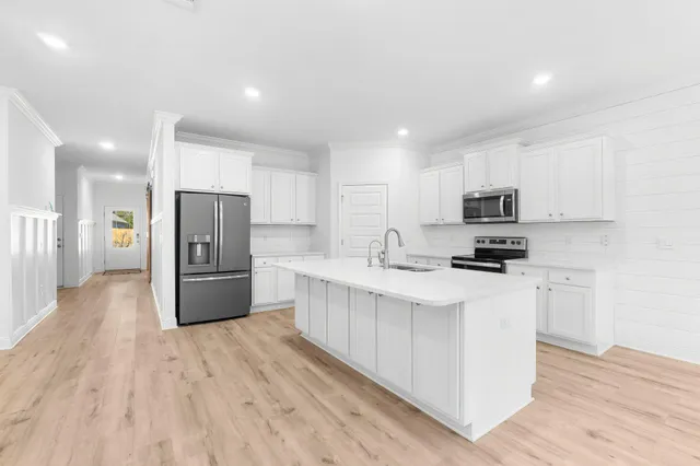 a kitchen with stainless steel appliances a refrigerator sink and microwave