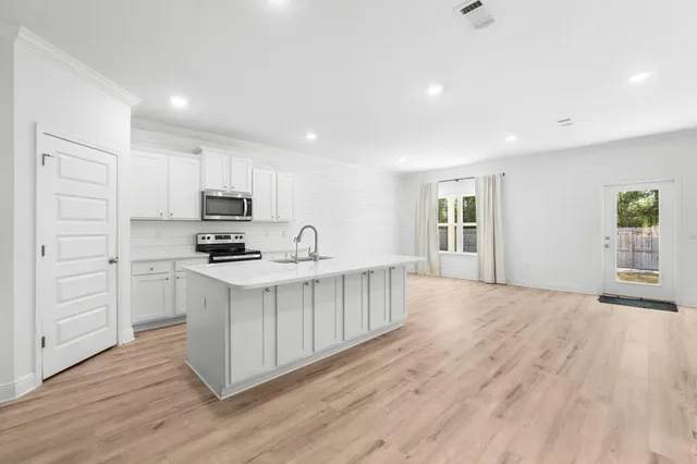 a kitchen with white cabinets and stainless steel appliances