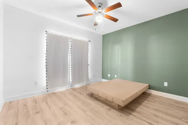 a bedroom with a bed and a ceiling fan