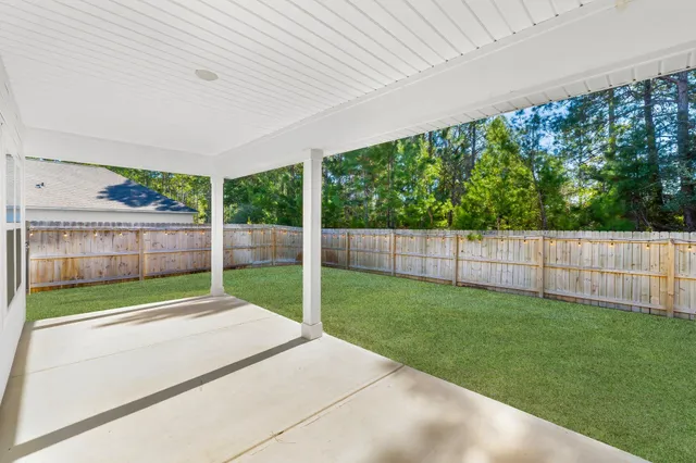 a view of a backyard with wooden fence