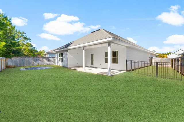 a view of a backyard with table and chairs and wooden fence