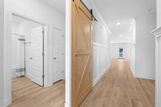 a view of a hallway with wooden floor and staircase