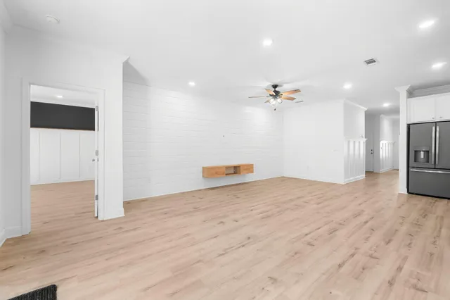 a view of a livingroom with a ceiling fan and kitchen view