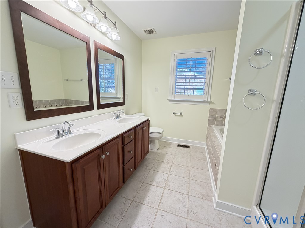10911 Weybridge Road Chester, VA 23831 - Photo 34 of 38 a bathroom with a double vanity sink a mirror and a shower