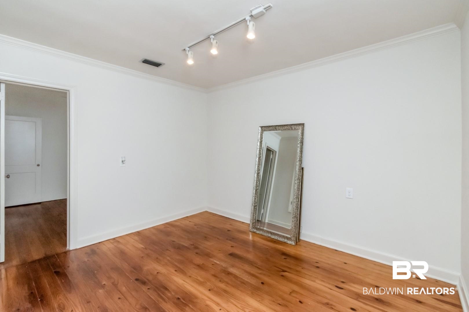 1906 Old Shell Road Mobile, AL 36607 - Photo 13 of 26 Unfurnished room featuring rail lighting, hardwood / wood-style floors, and crown molding