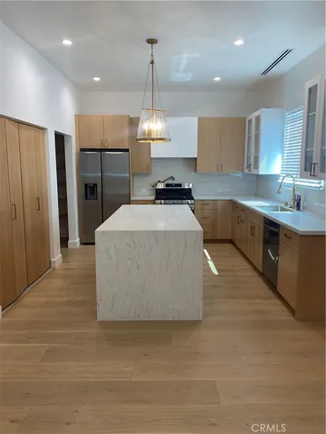 a large kitchen with kitchen island a sink stainless steel appliances and cabinets