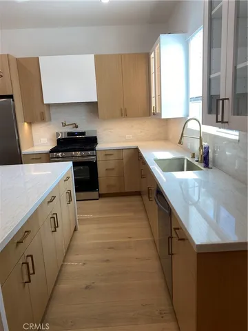 a kitchen with granite countertop a sink stove and cabinets