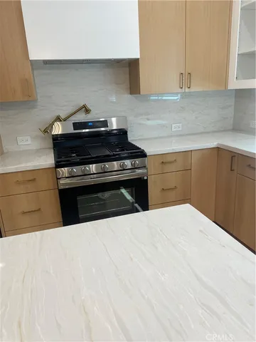 a kitchen with a stove and white cabinets