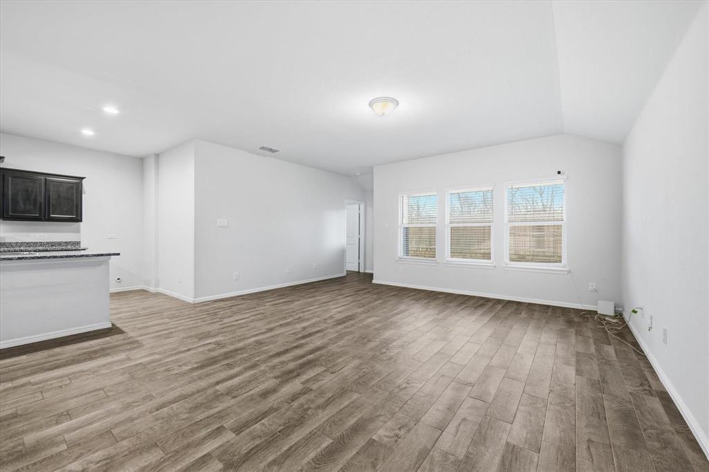 9308 Desertrock Road Fort Worth, TX 76131 - Photo 6 of 29 a view of an empty room with wooden floor and a window
