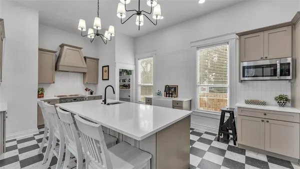 a kitchen with kitchen island a stove a sink a refrigerator dining table and chairs