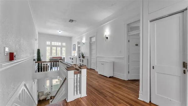 a view of a hallway with wooden floor windows