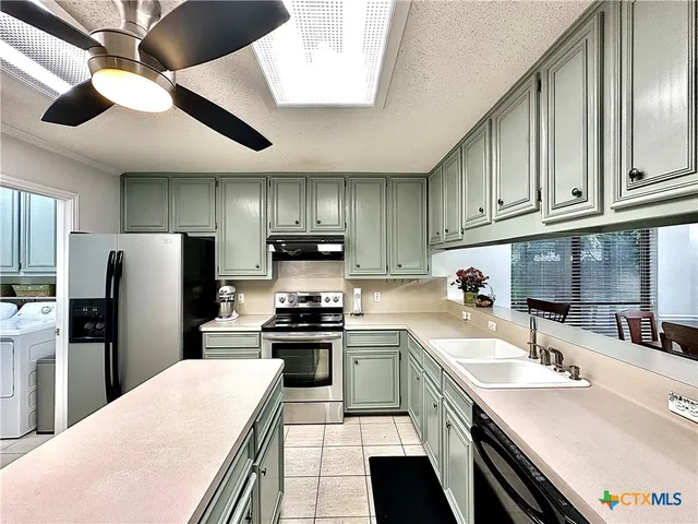 an empty room with windows and ceiling fan
