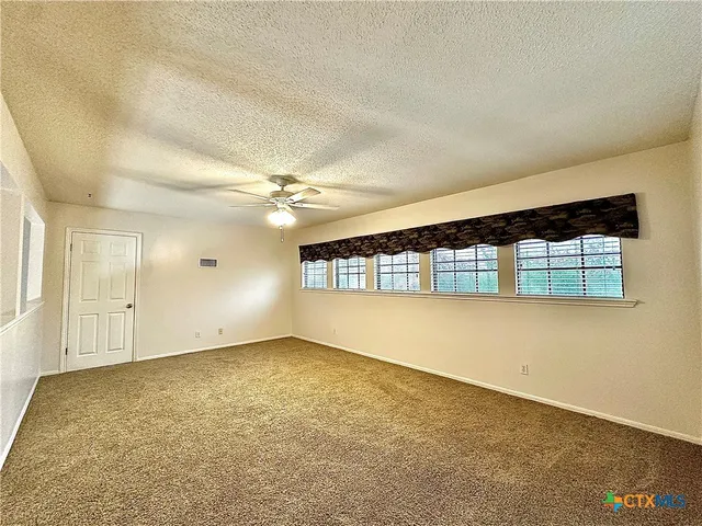 a bedroom with a bed and a ceiling fan with wooden floor