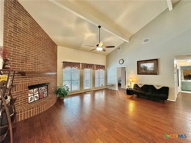 a view of a livingroom with wooden floor and fireplace
