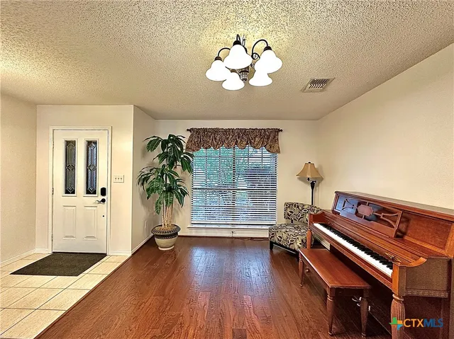 a kitchen with stainless steel appliances a sink a stove a refrigerator cabinets and chairs